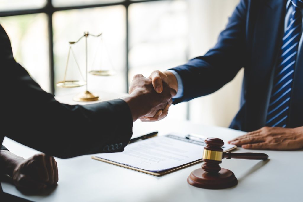 Servicios Portrait of lawyers agreeing holding hands in lawyer office giving advice and advice on case consult